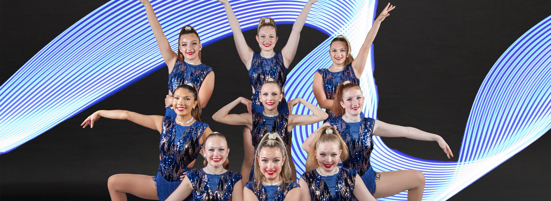 dance group posing in front of blue wavy line